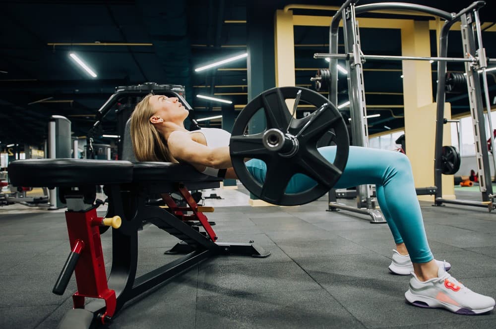 A woman doing glute bridge as one of the compound leg exercises.